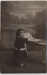 AK Foto Kind blättert im Buch Ansichtskarten 1910
