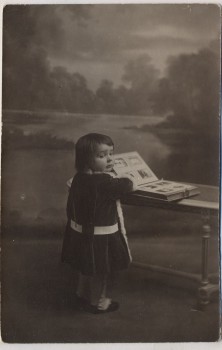AK Foto Kind blättert im Buch Ansichtskarten 1910